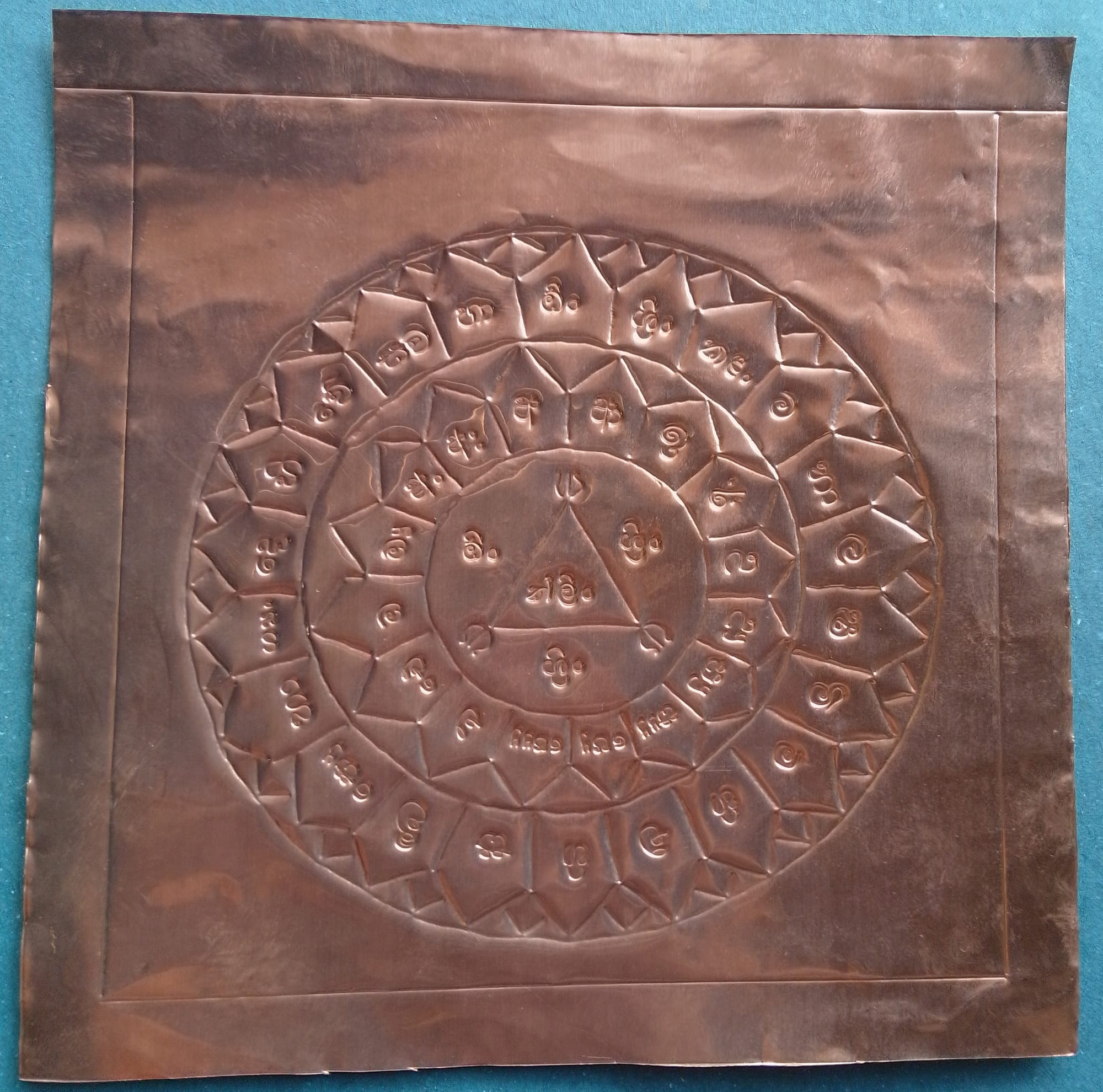 Sacred geometric Lakshmi Yantra engraving on a copper plate, used in Hindu rituals to attract wealth, prosperity, and abundance. Spiritual Vedic mandala for vastu and meditation.